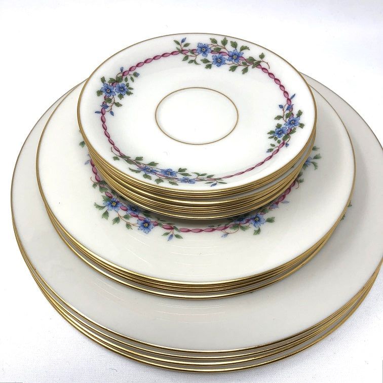 Stack of ivory vintage fine china with floral border in 3 size plates.