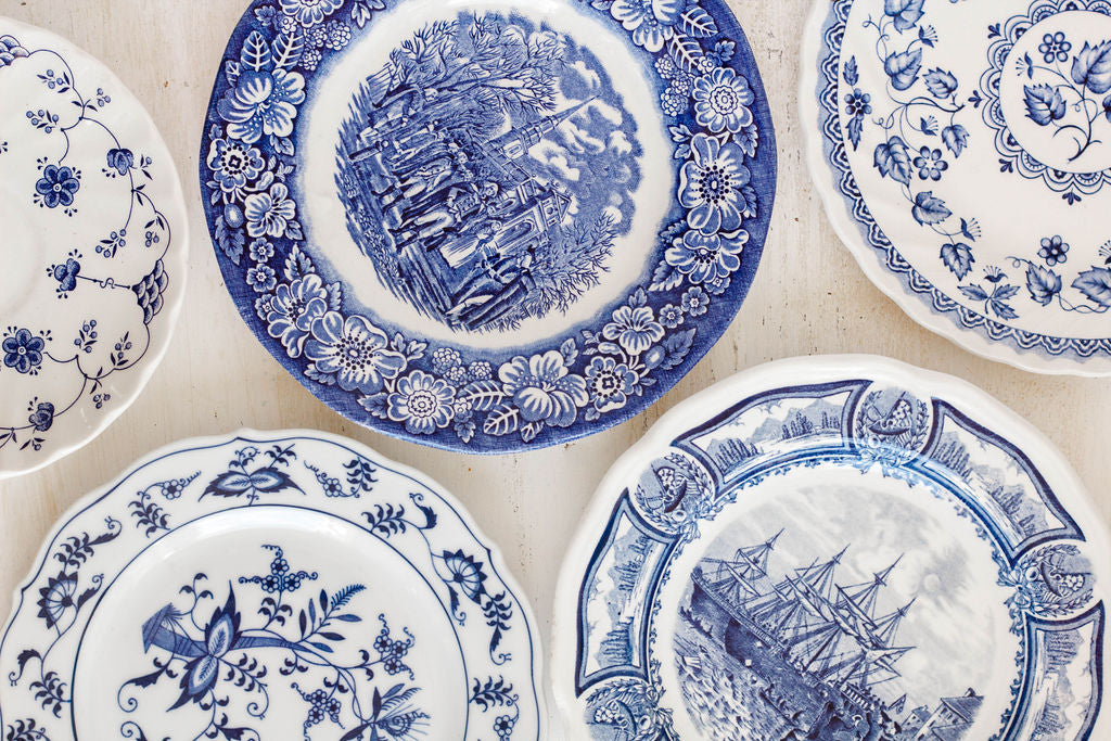 assortment of eclectic blue and white transferware china patterns on dessert plates