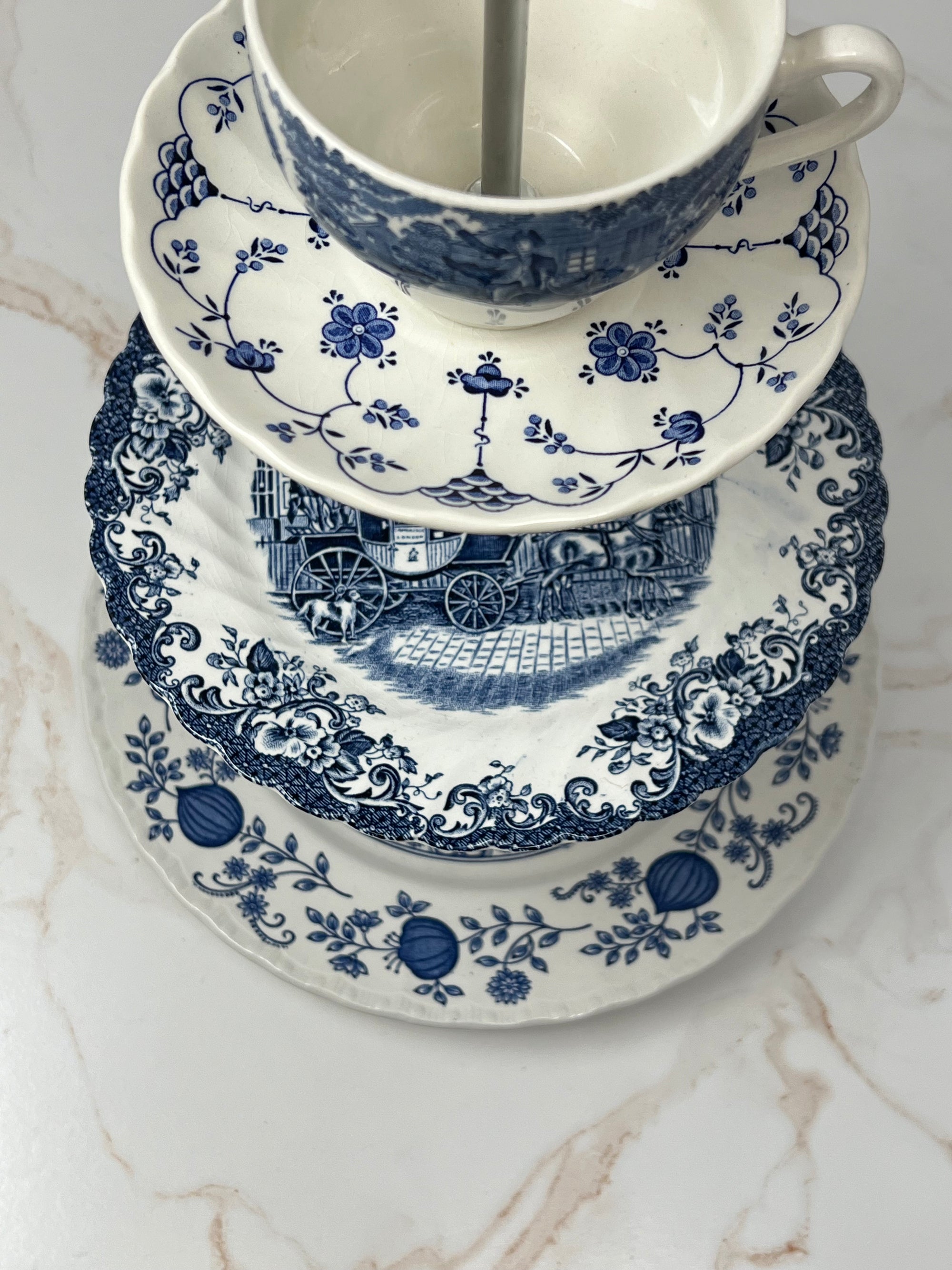 Close-up of eclectic blue and white china patterns on 3- tiered tray with silver T hardware