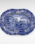 A blue and white vintage serving platter with a detailed landscape scene in the center and ornate floral borders