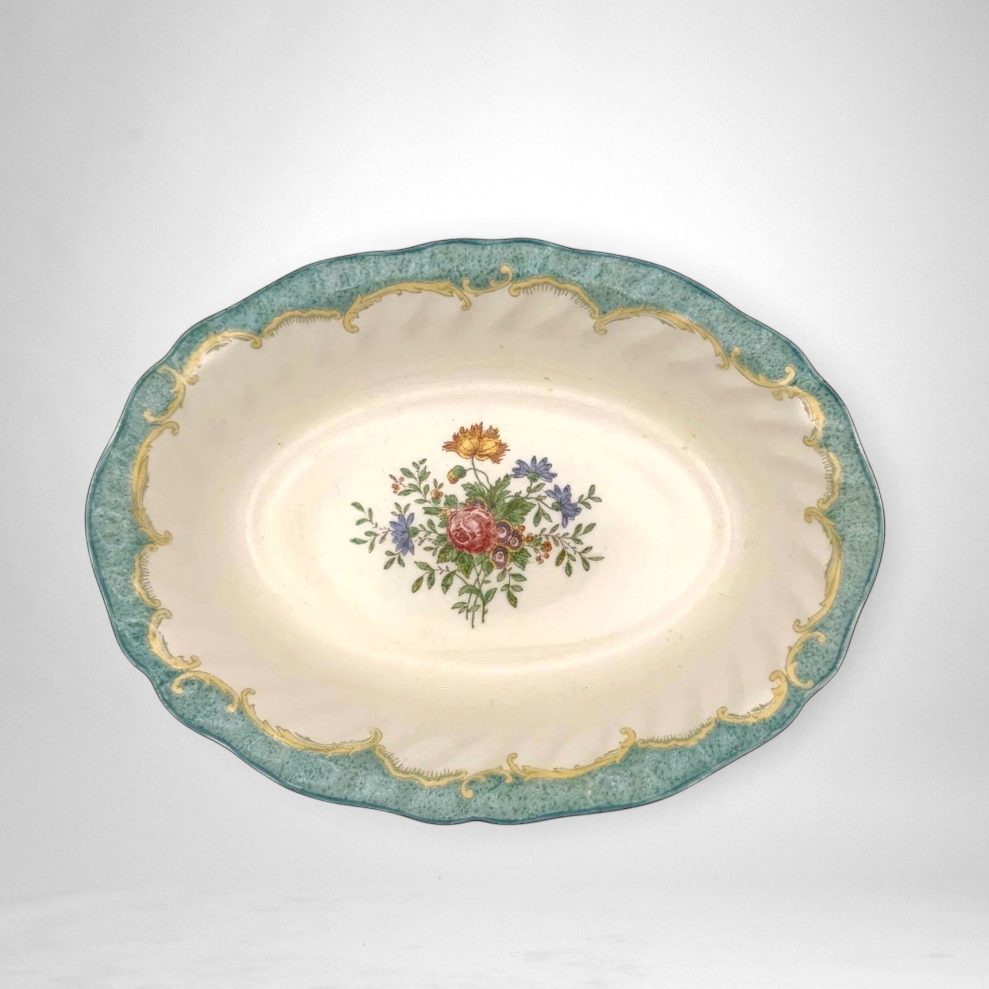 The Brooklyn Teacup oval serving bowl with a cream center, floral bouquet, and ornate teal and gold scalloped rim.