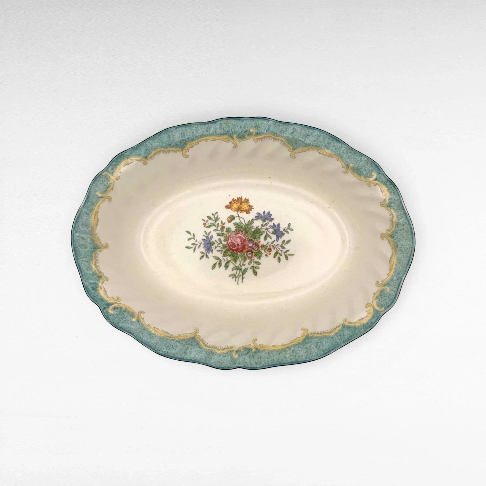 The Brooklyn Teacup oval serving bowl with a cream center, floral bouquet, and ornate teal and gold scalloped rim.