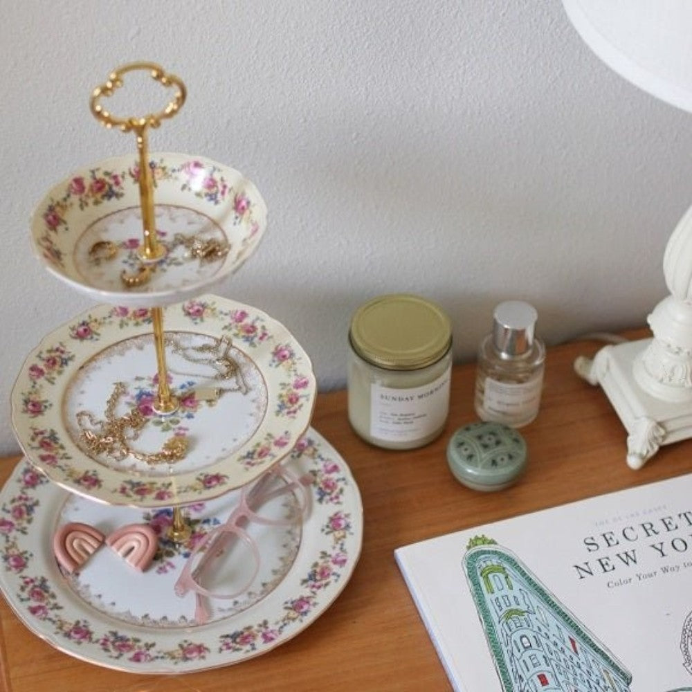 The Brooklyn Teacup custom three-tier tray made from vintage floral china plates with a gold-tone metal handle.