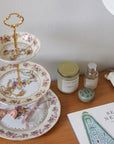 The Brooklyn Teacup custom three-tier tray made from vintage floral china plates with a gold-tone metal handle.
