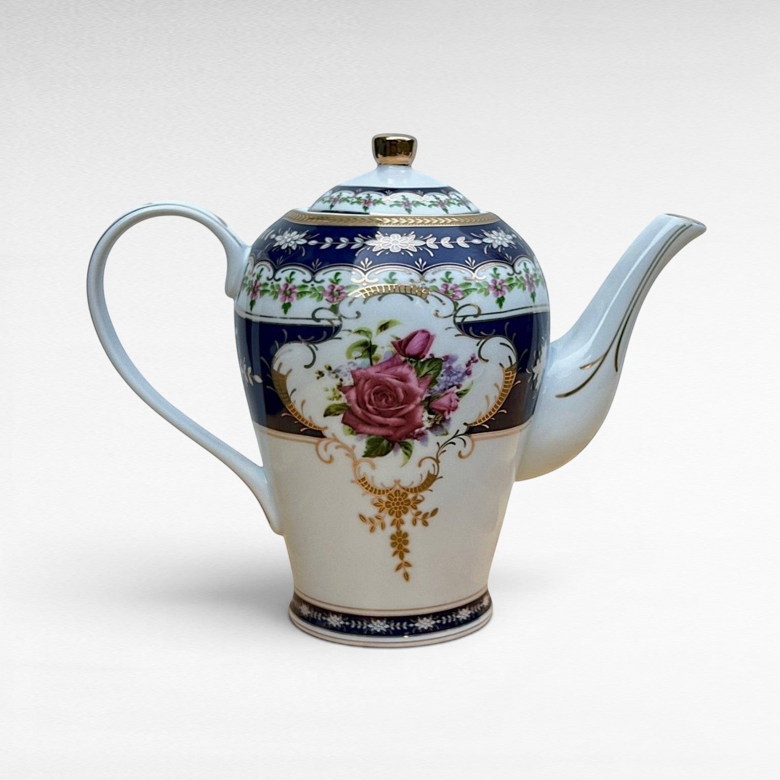 The Brooklyn Teacup vintage porcelain coffee pot featuring a blue and white floral rose pattern with gold trim.