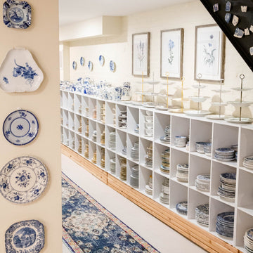 the Brooklyn Teacup studio, plate wall and long row of bookshelves stacked with china. 